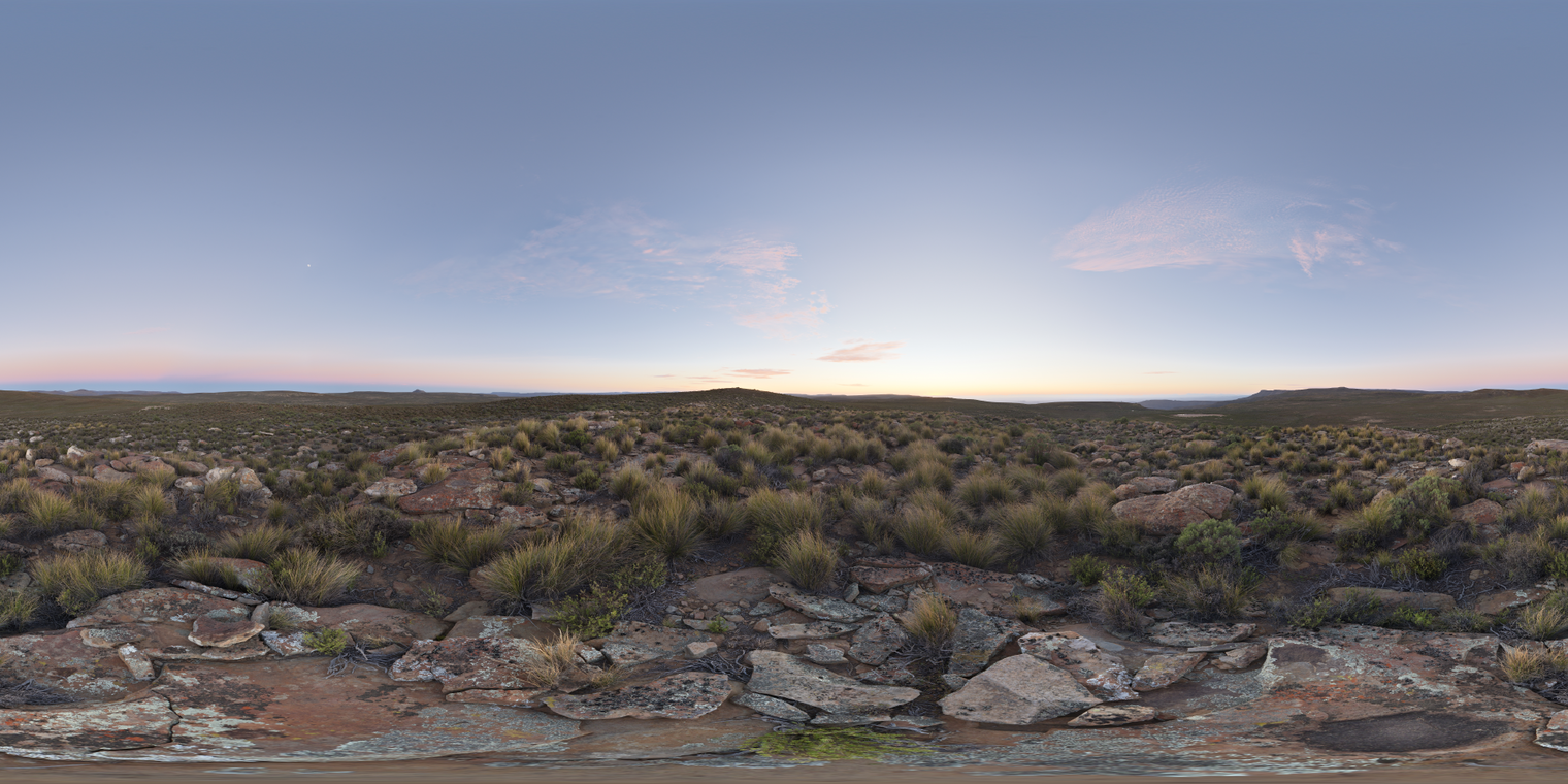 Free, unclipped 24K HDRI of a rocky grassland at dawn: soft pre-sunrise glow, pale blue sky with pink clouds, cool ambient light and gentle warm horizon tint.