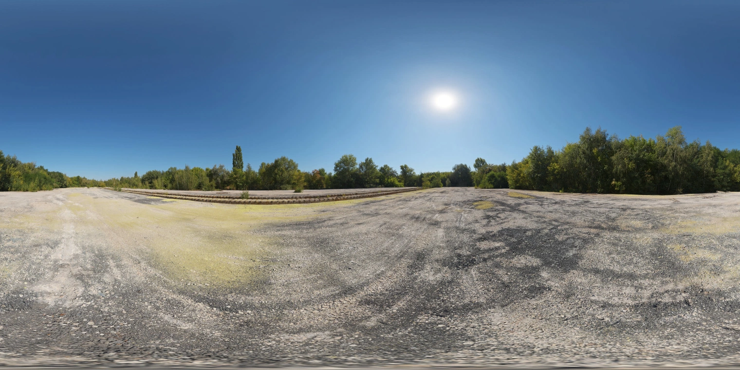 Free 16K unclipped HDRI: clear midday sun with high-contrast natural light over an abandoned industrial field fringed by trees, crisp summer atmosphere.