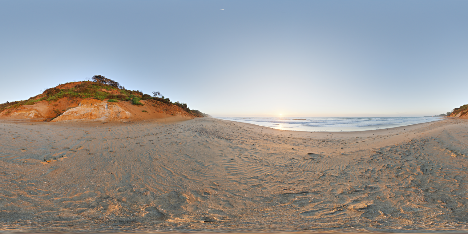Unclipped, free 24K HDRI of a beach sunrise: clear sky, low sun over calm surf, warm golden highlights on sand, cool blue fill and long soft shadows.
