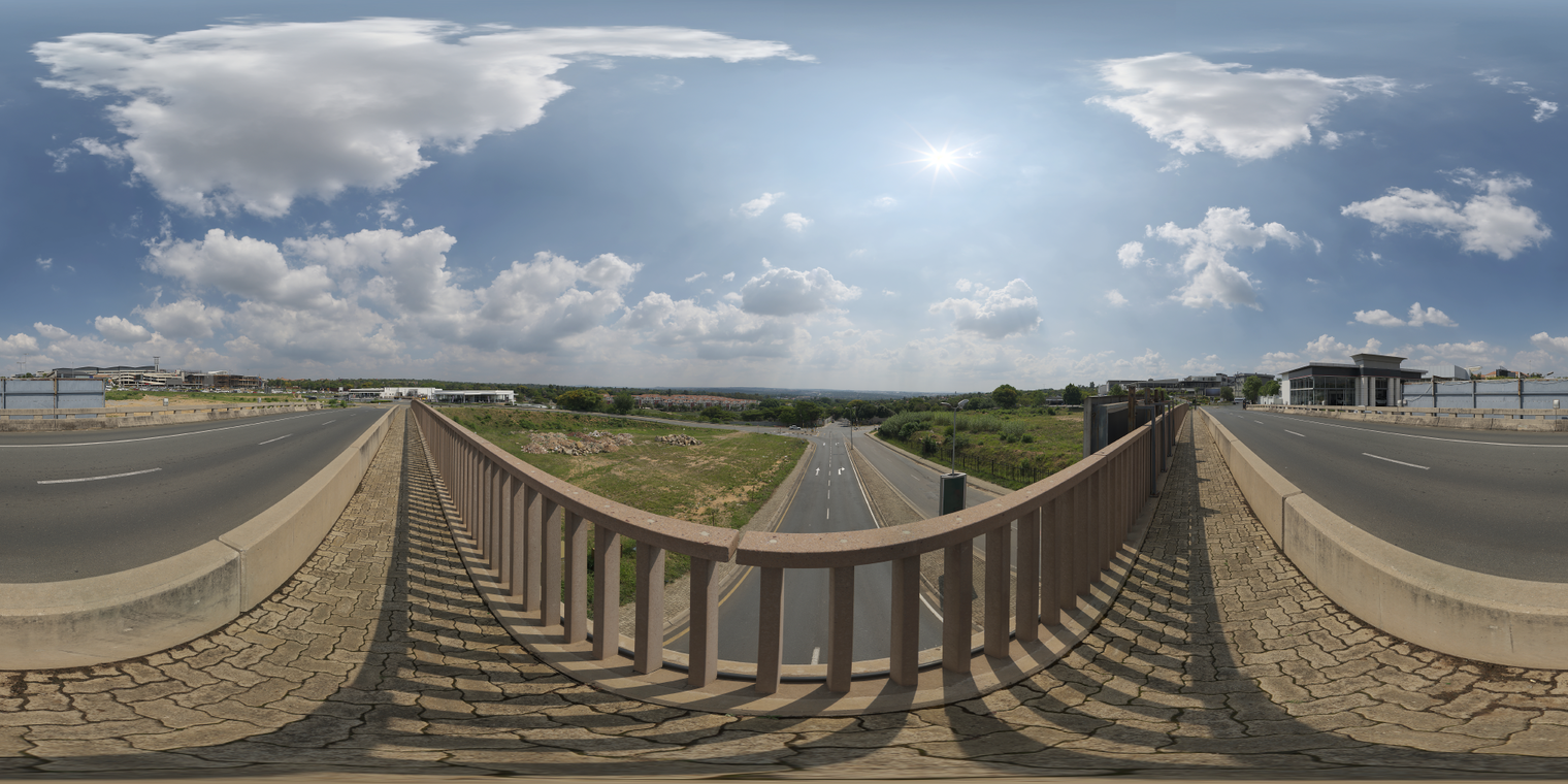 Free, unclipped 24k HDRI: midday partly cloudy sky over a bridge, bright sun, crisp high-contrast shadows, neutral tones and slight distant haze.