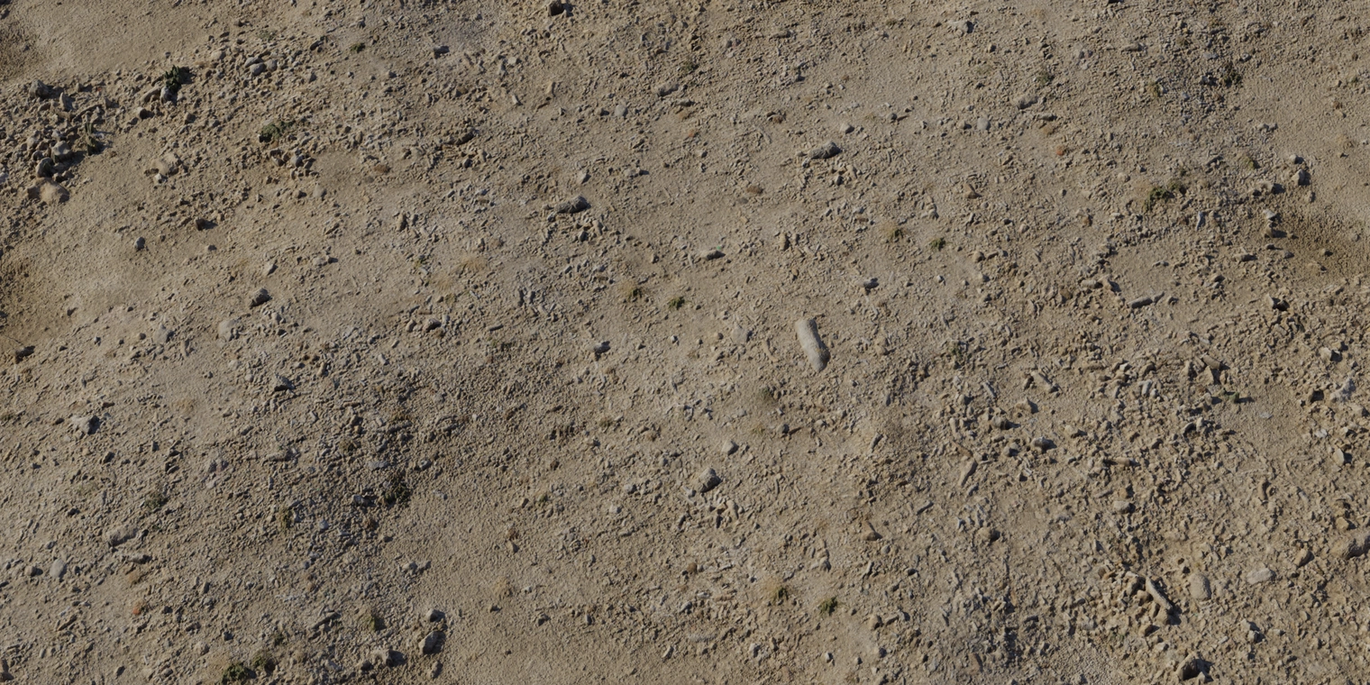 Free 8K texture of damp coastal sand with brown, rough grain, scattered pebbles and gravel, patchy dirt and a subtle moisture sheen.