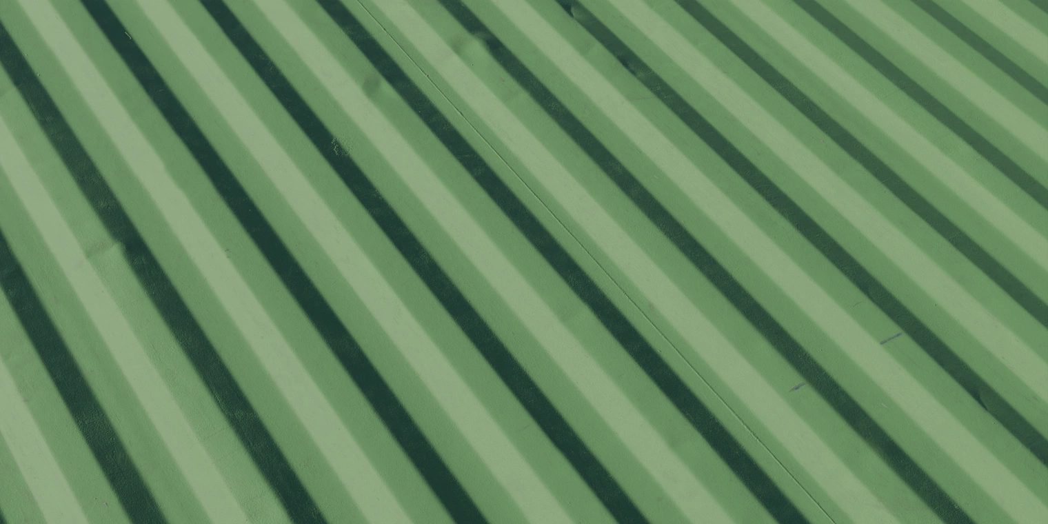 Free 8K texture of green corrugated metal container side, worn, chipped paint with subtle dents, scratches and light grime on an industrial, battered surface.