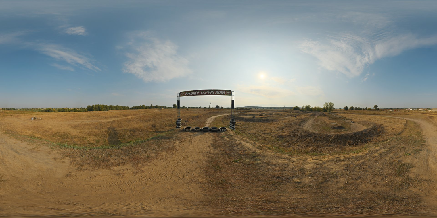 Unclipped, free 16K HDRI: sunlit dirt bike track in warm late-morning/afternoon light - partly cloudy sky, high-contrast directional sun, dry dusty terrain and tire marks.
