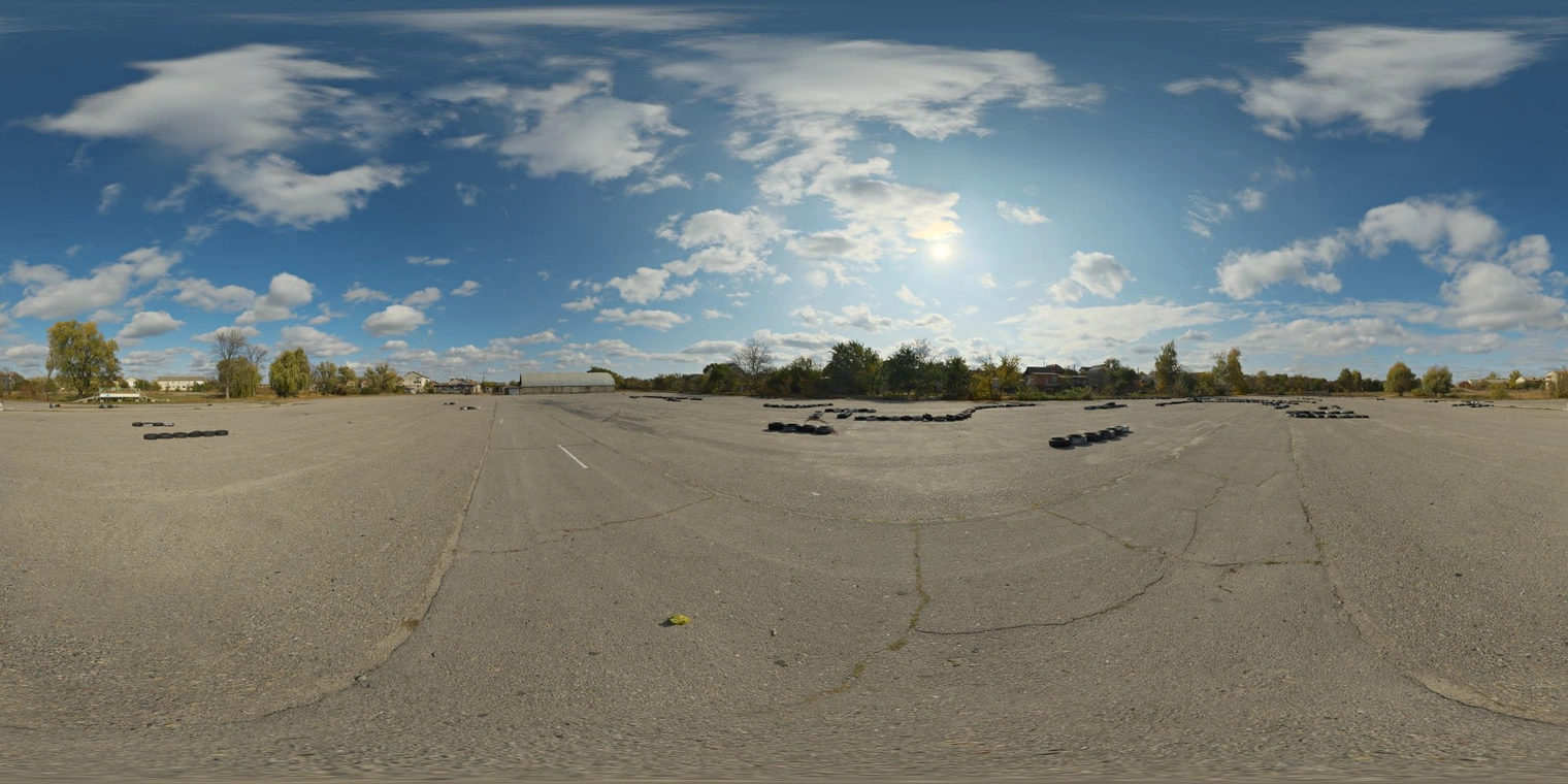 Free 16K, unclipped, bright high-contrast afternoon sun over a cracked asphalt driving school lot with scattered tires and a partly cloudy blue sky.