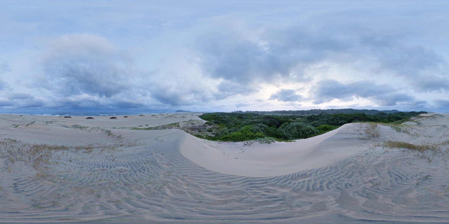 Unclipped, free 24K HDRI with overcast dusk at sandy dunes; cool blue tones, faint horizon glow, soft diffuse light and low contrast reflections.