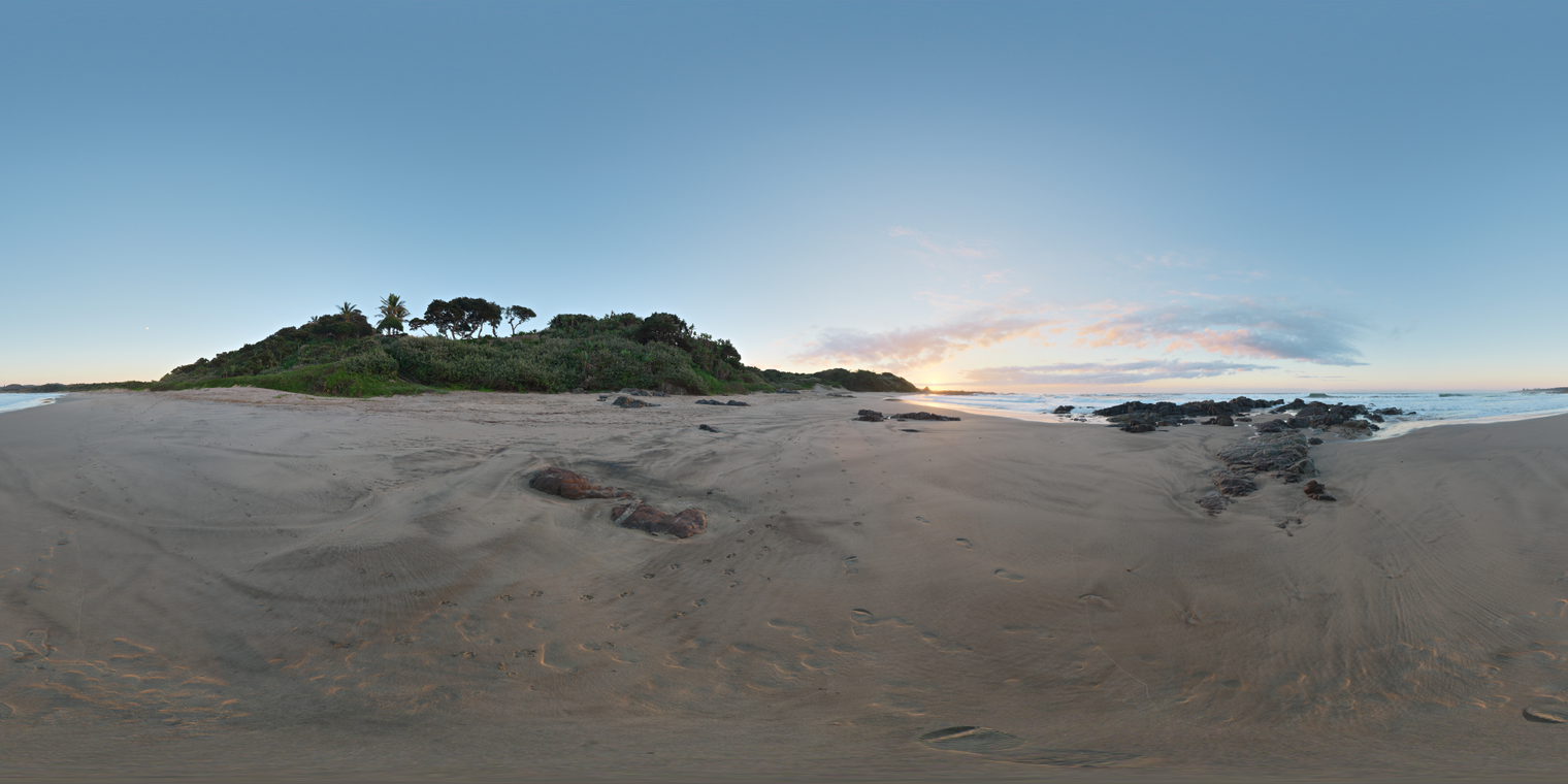Unclipped, free 20K HDRI of Ivy Beach at sunrise: blue sky, warm horizon glow, soft clouds, subtle shadows on rippled sand, wet rocks and pretty clouds.