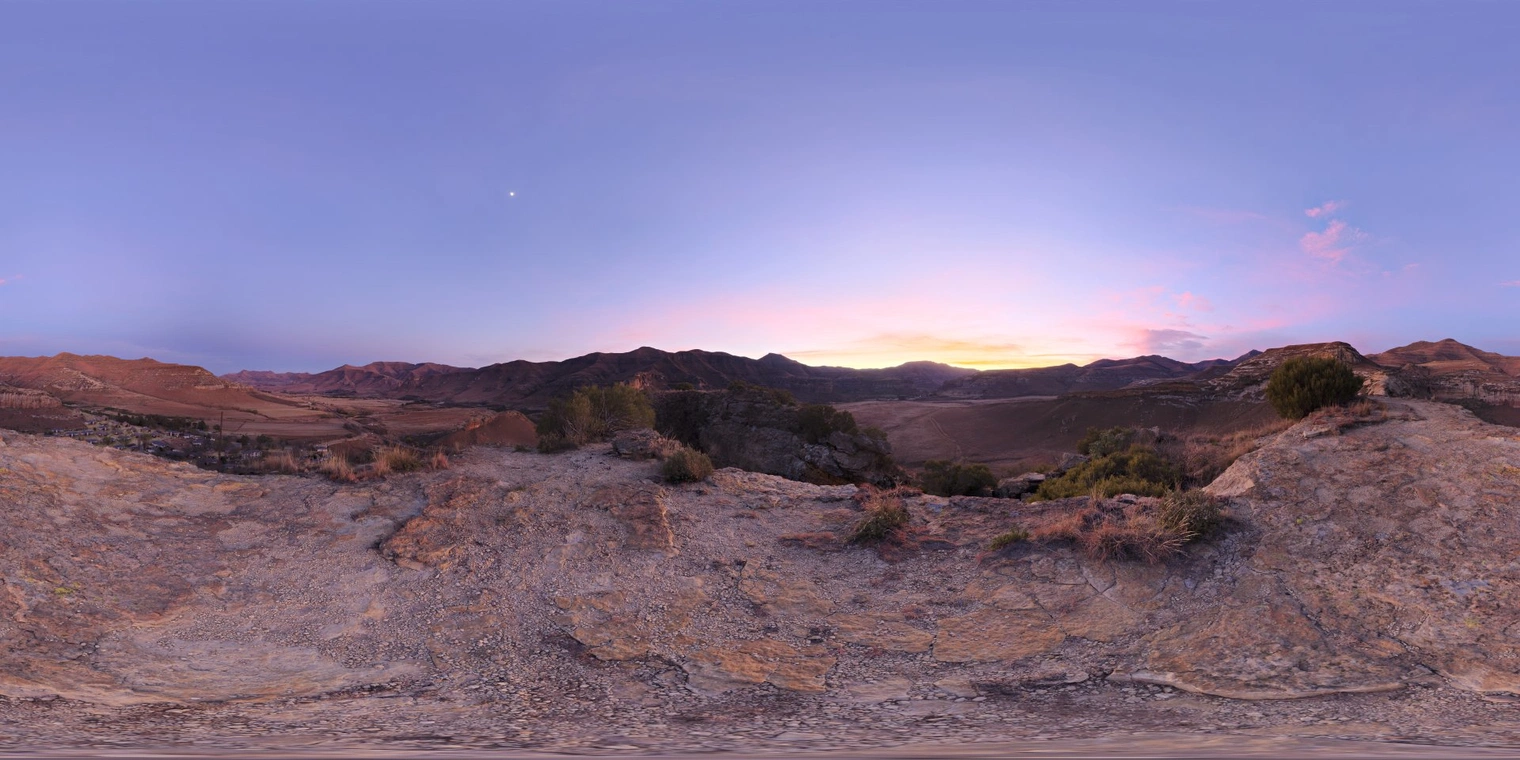 Free 16K unclipped HDRI of a rocky mountain valley at dawn, soft pastel sunrise glow, partly cloudy sky, medium-contrast natural light with cool violet tones.