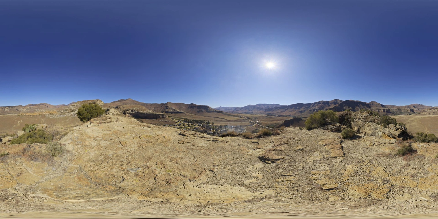 Free 16K unclipped HDRI: clear afternoon sun over a dry rocky mountain valley, warm high-contrast natural light with sharp shadows.