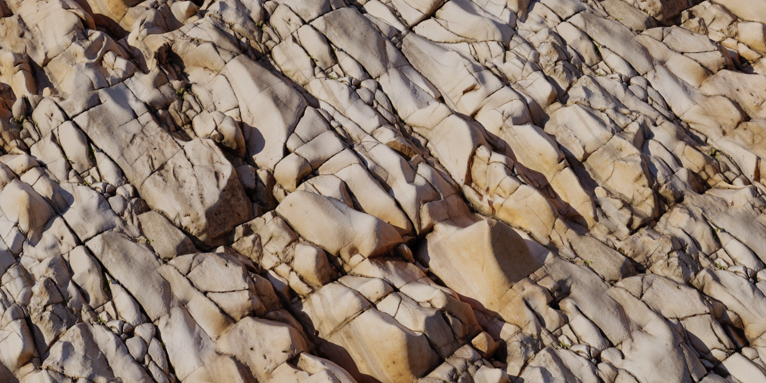 Free 8k marble cliff texture: weathered metamorphic rock with creamy-tan veining, deep fissures, cracks and subtle dirt; rough, fractured strata.