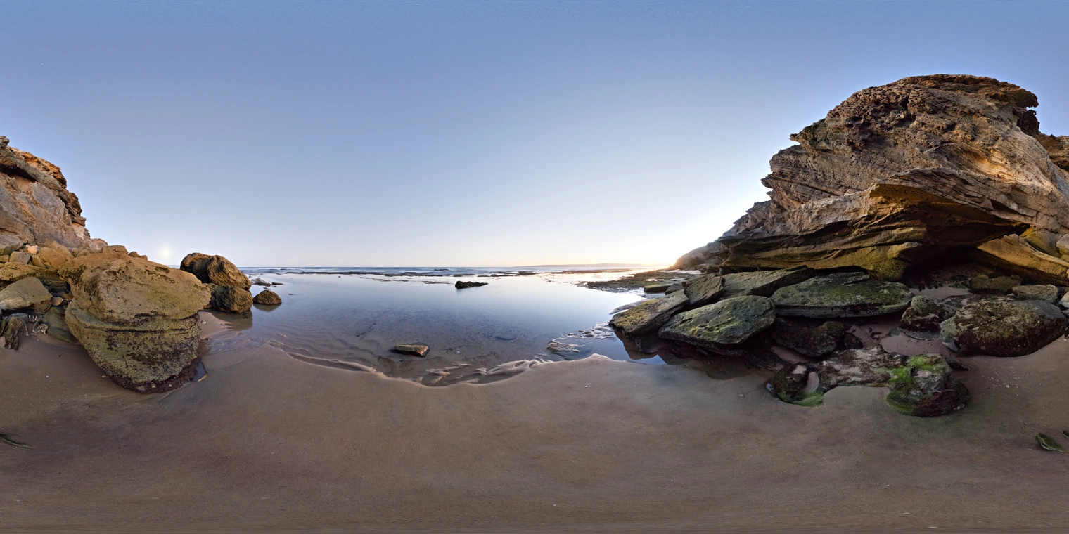 Unclipped, free 24K HDRI of a rocky seaside cave at low tide. Cool blue twilight with a warm horizon glow, soft reflections, long shadows and gentle contrast.
