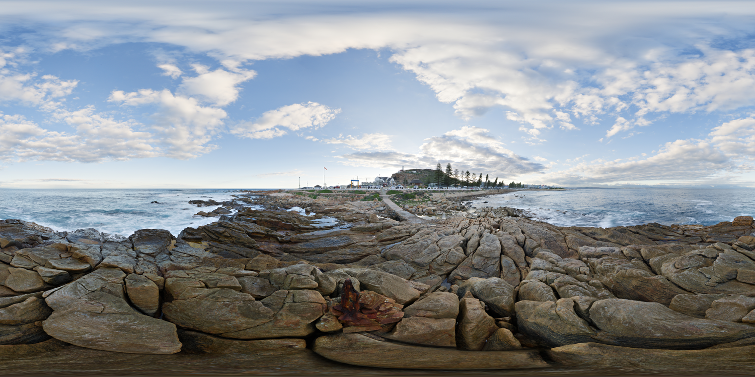 Free, unclipped 24K HDRI of a rocky shoreline at Mossel Bay: soft afternoon sun, partly cloudy sky, low-contrast lighting, cool ocean tones and rough waves.