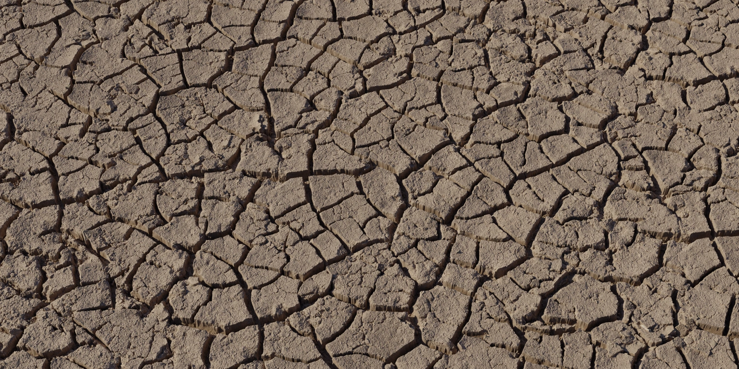 Free 8K texture of cracked dry riverbed mud: rough, weathered, flaky plates with deep fissures and clayey brown, uneven surface.