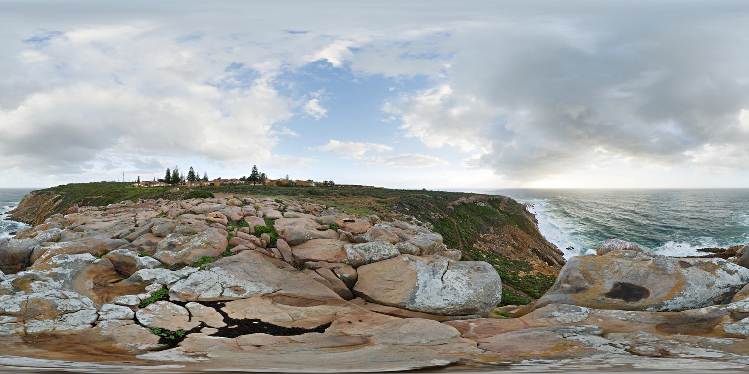 Unclipped, free 24K HDRI of a rocky ocean lookout under broken clouds, cool coastal daylight with soft shadows and a dramatic sea cliff.