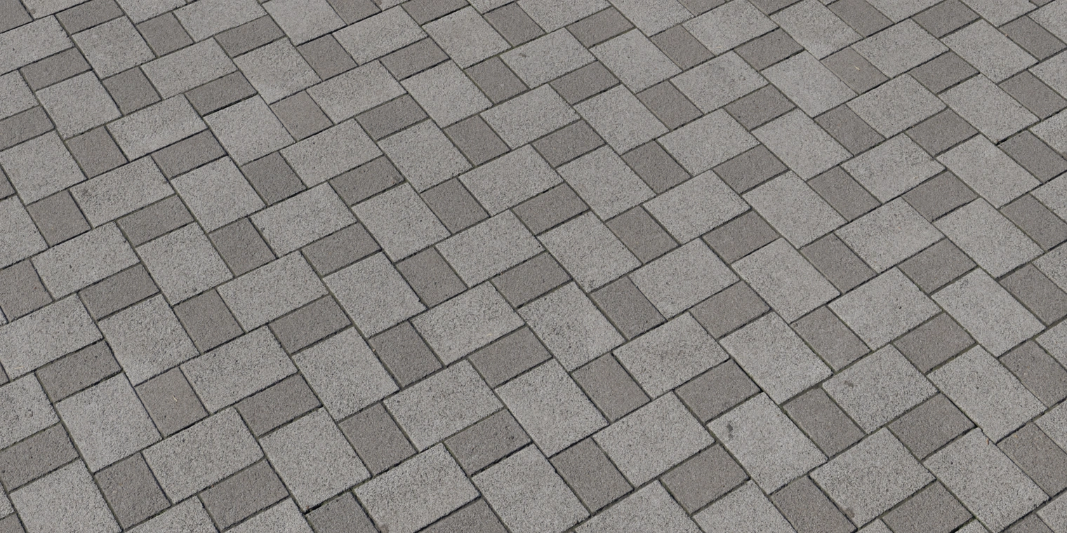 Free 8K texture: patterned gray concrete brick pavement with staggered rectangular blocks, fine gritty surface, subtle weathering and recessed grout lines.