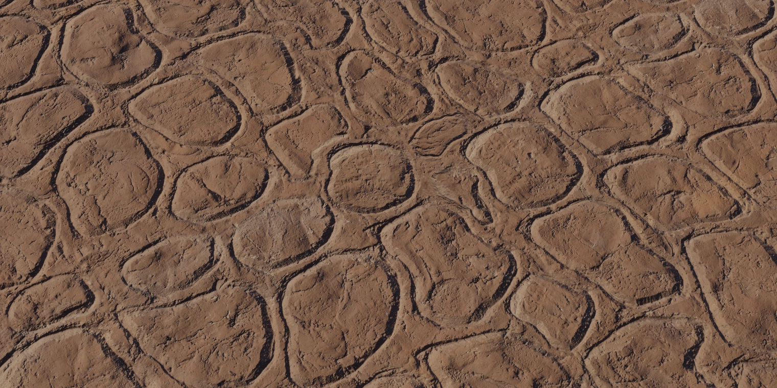 Free 8K texture of a patterned brown clay wall with an uneven, weathered surface - dry, cracked and chipped stones, stained and worn with rough, tactile detail.