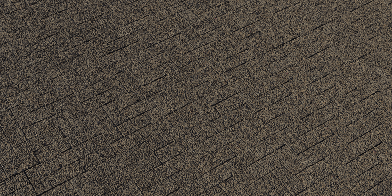 Free 8k texture of herringbone interlocking bricks with a coarse, pebble-embedded, weathered surface, rough uneven grain and recessed grout lines.