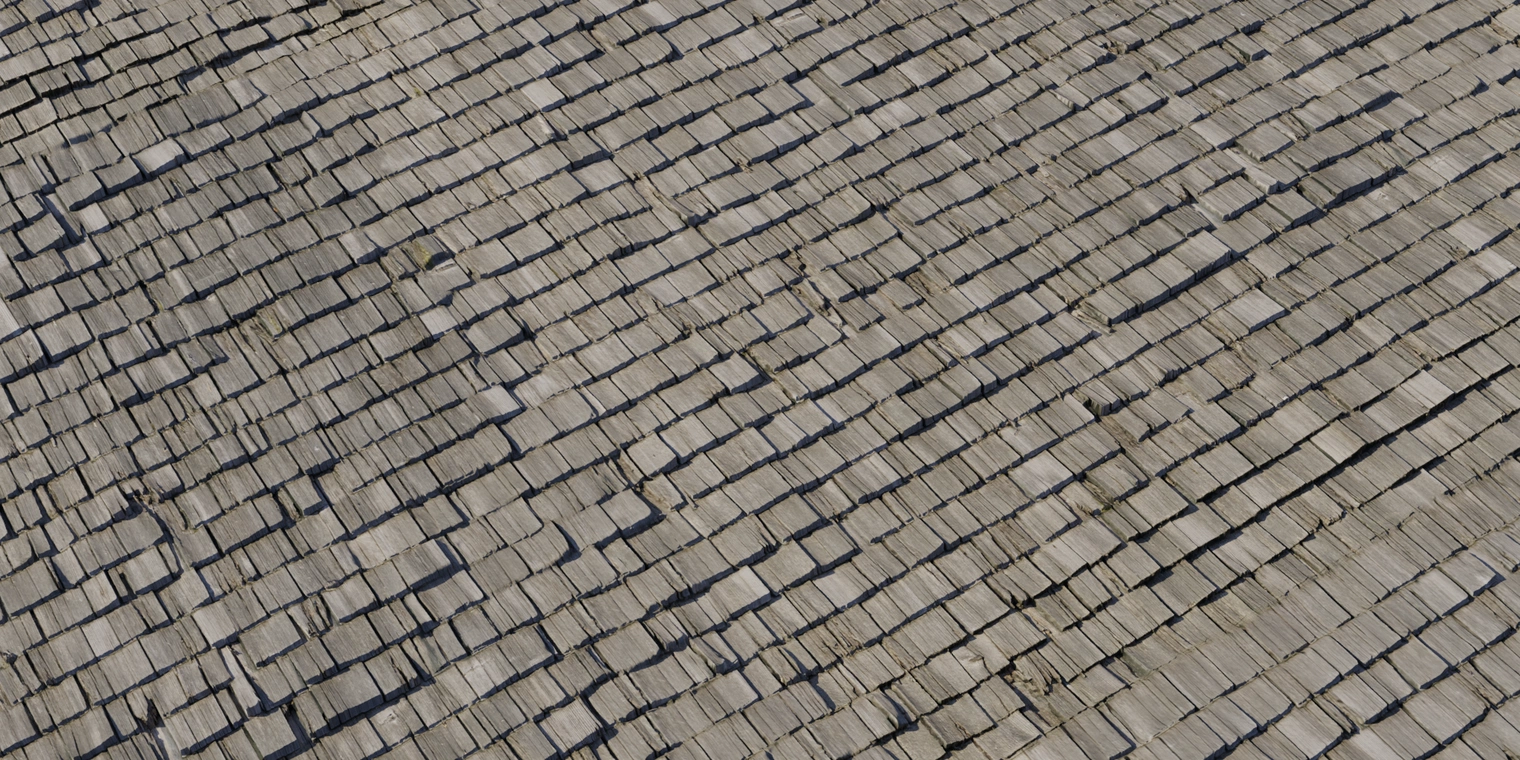 Free 8K texture of a weathered slate roof: uneven overlapping flat tiles, rough chipped edges, subtle discoloration and moss staining across gray-brown surfaces.