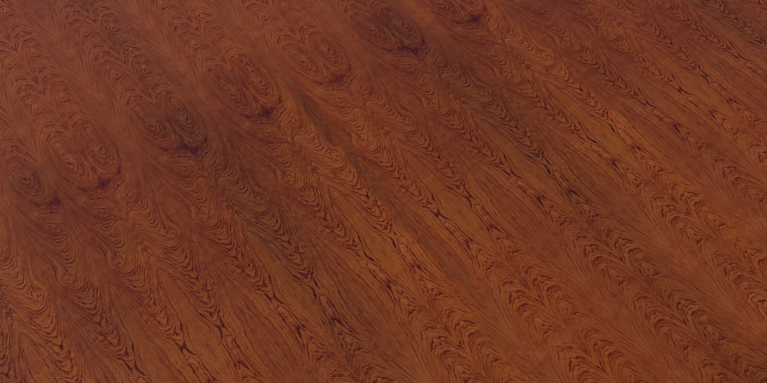 Free 16K texture: lacquered rosewood veneer with warm reddish-brown tones, pronounced natural grain and a smooth, coated finish for realistic wood surfaces.