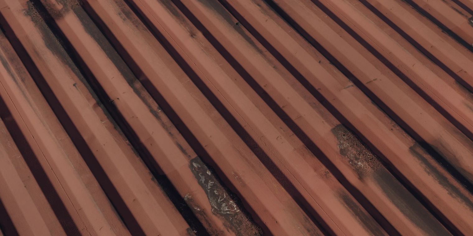 Free 16K texture of rusty painted corrugated metal: weathered red paint with cracking, flaking and dark corrosion on rough, discolored steel sheets.