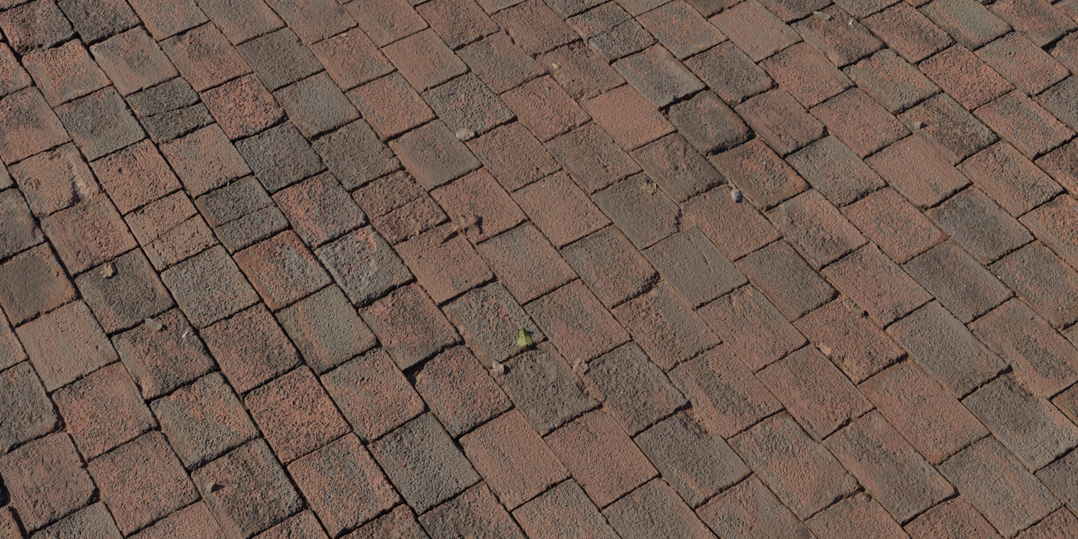 Free 8K texture of short red brick paving with weathered, rough surfaces, worn mortar lines, small debris and subtle color variation.