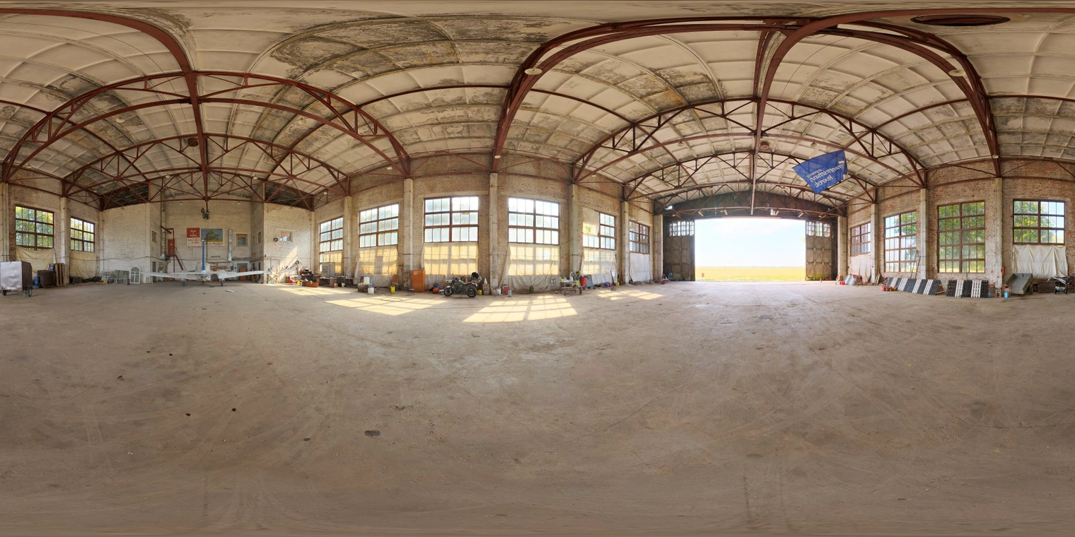 Unclipped, free 16K HDRI of a small hangar: soft warm natural morning/afternoon light, low-contrast industrial warehouse mood with large window highlights.