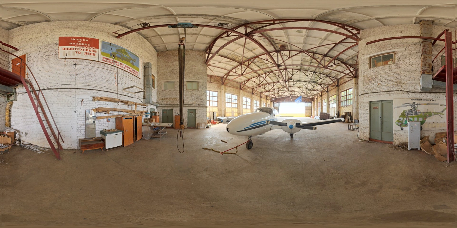 Free 16K unclipped HDRI of a small European industrial hangar with natural morning/afternoon light - soft warm sun through high windows, medium contrast, dusty mood.