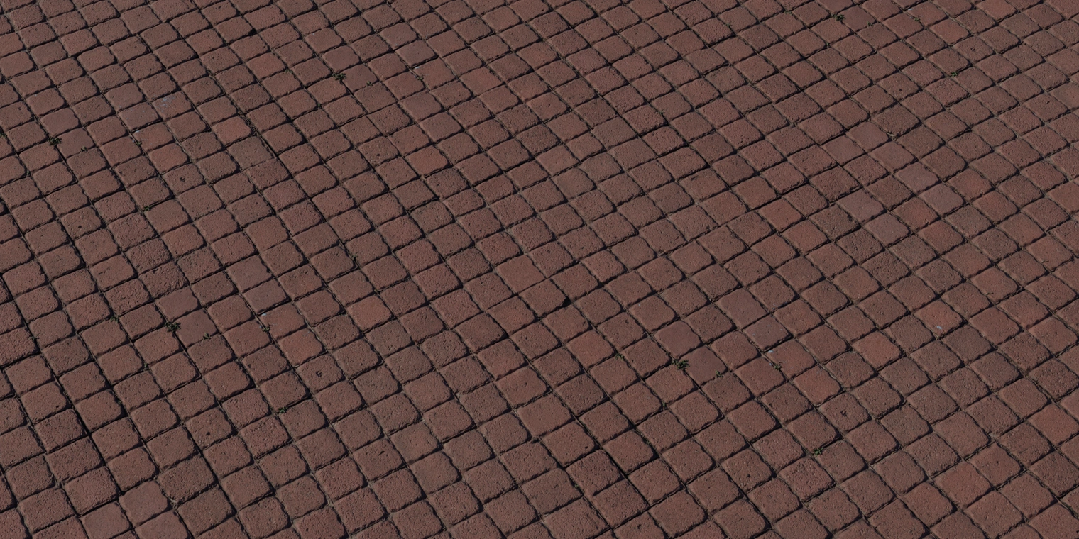 Free 8K texture of reddish-brown square pavers with rough, worn surfaces, uneven edges, and dark recessed joints.
