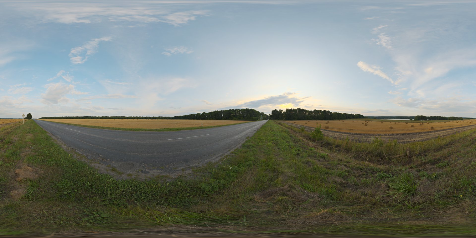 Free 16K unclipped HDRI of a straw-roll farm field at sunset - soft, low-contrast natural light, warm horizon glow, partly cloudy sky and an asphalt road.