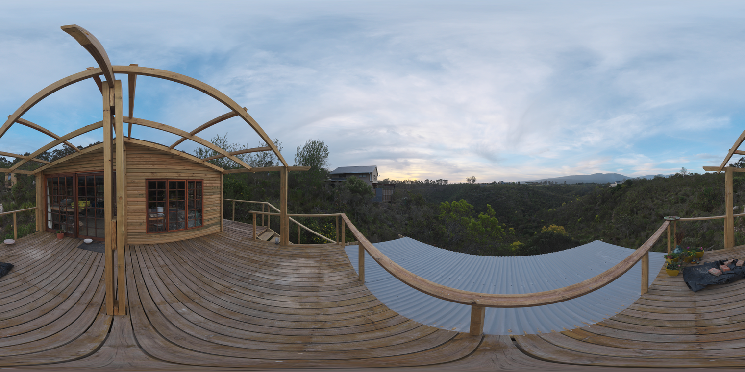 Unclipped, free 20k HDRI of a wooden treetop balcony at sunset - low-contrast, soft natural light, partly cloudy sky over a forested valley.