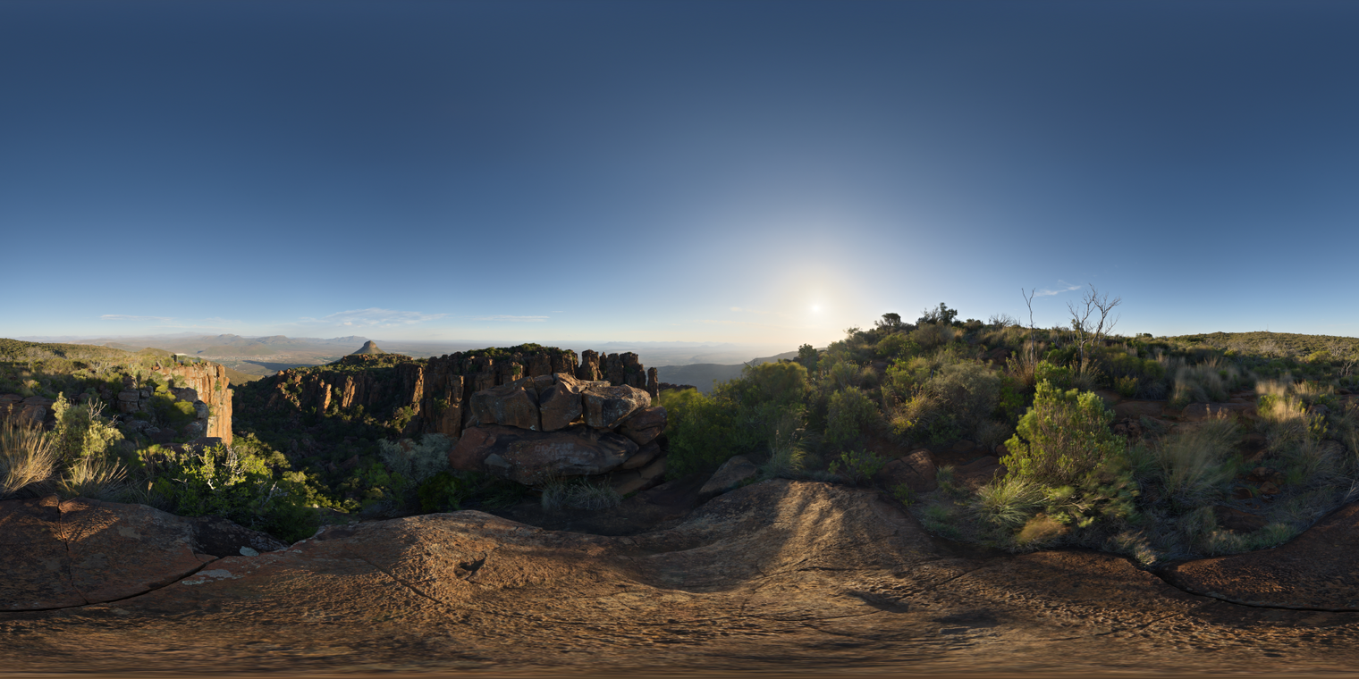 Unclipped, free 24K HDRI of a rocky valley at golden hour: clear sky, warm sun near horizon, crisp contrast, long shadows, vivid scrub and cliffs, dry tones.