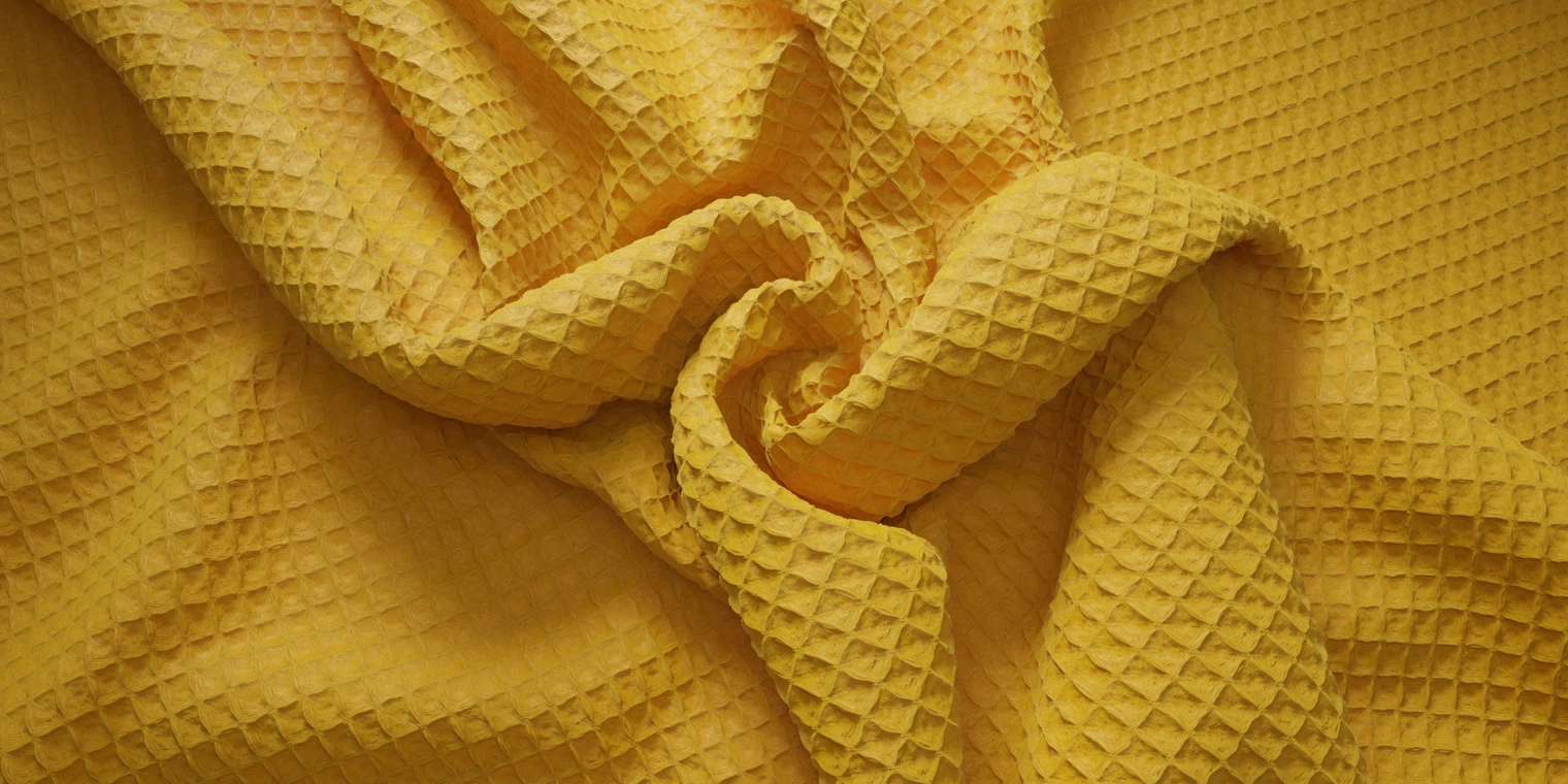 Free 8K texture of yellow waffle-pique cotton with pronounced grid, soft matte surface and recessed squares - great for textiles, linens, apparel and props.