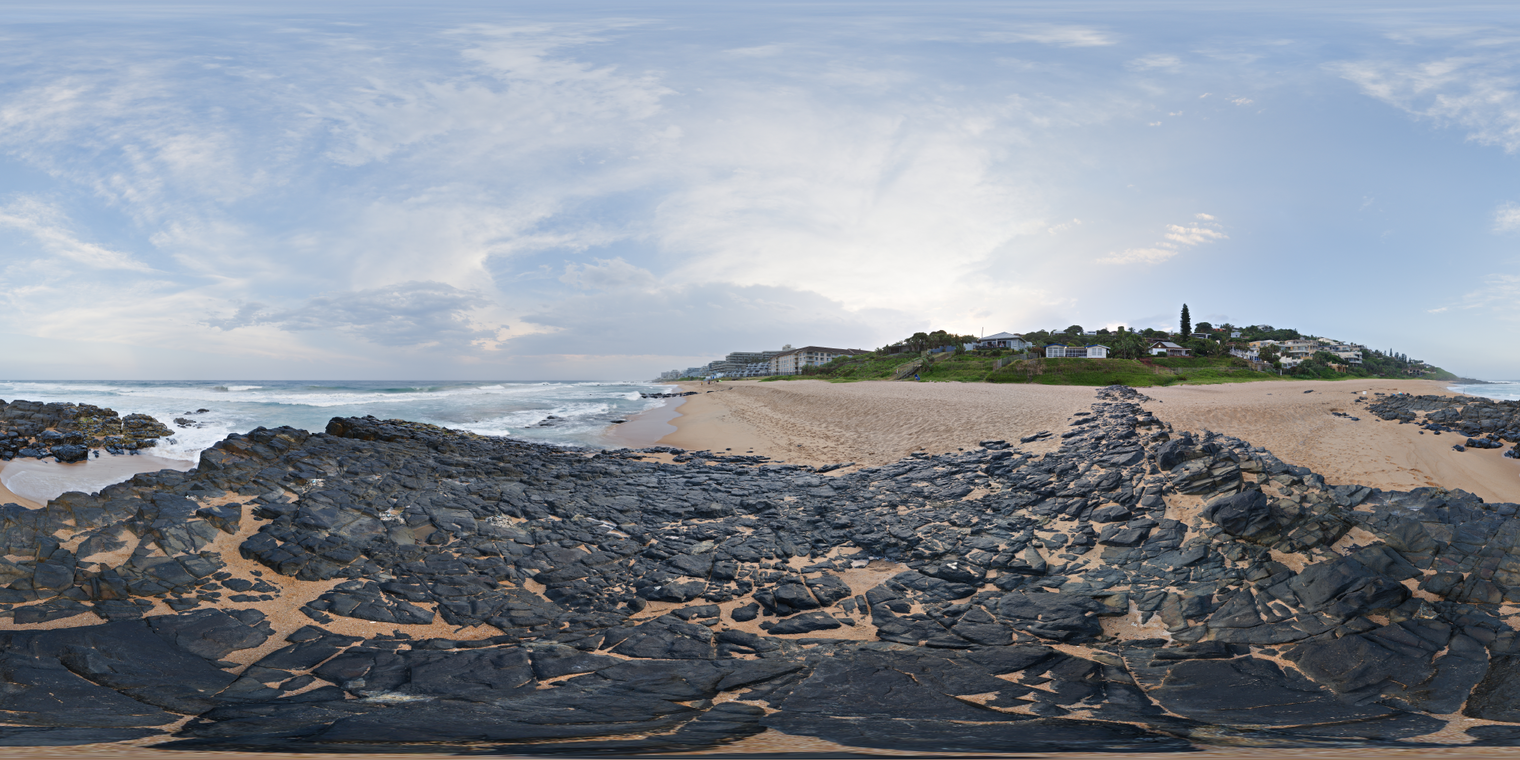 Unclipped, free 24K HDRI of Willards Beach with dark rocks, sandy shore and gentle surf under bright, hazy clouds; soft light and mild contrast.