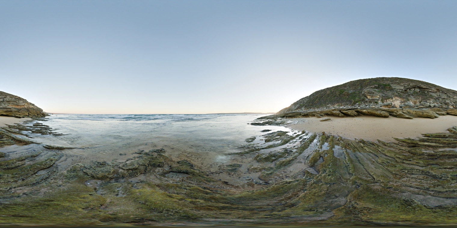 Unclipped, free 24K HDRI of a rocky beach at low tide in soft dusk light: pale blue sky, wet rocks, gentle surf and a cool, crisp mood.