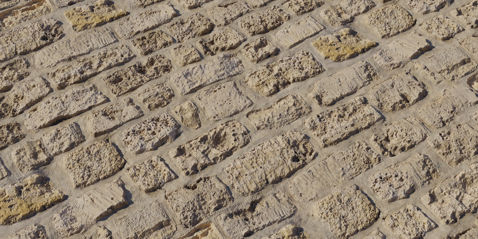 Free 8K texture: weathered yellow stone wall with rough, chipped blocks, cracked mortar and discolored, scratched concrete-rock surface.